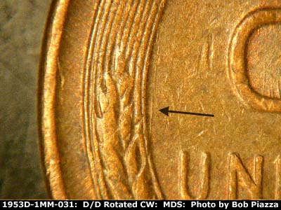 Die-stage C marker on 1953D•1MM•031 showing N/S die scratch from middle left wheat stalk.