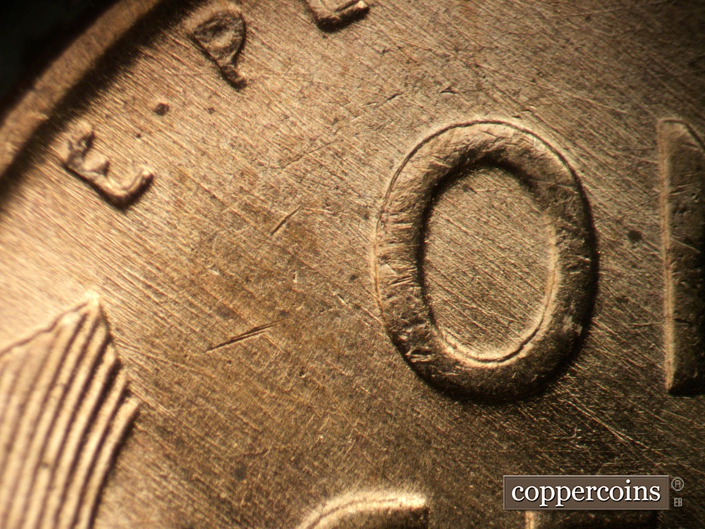Die-stage B marker on 1953D•1MM•031 showing SE die scratches cover upper left of reverse.