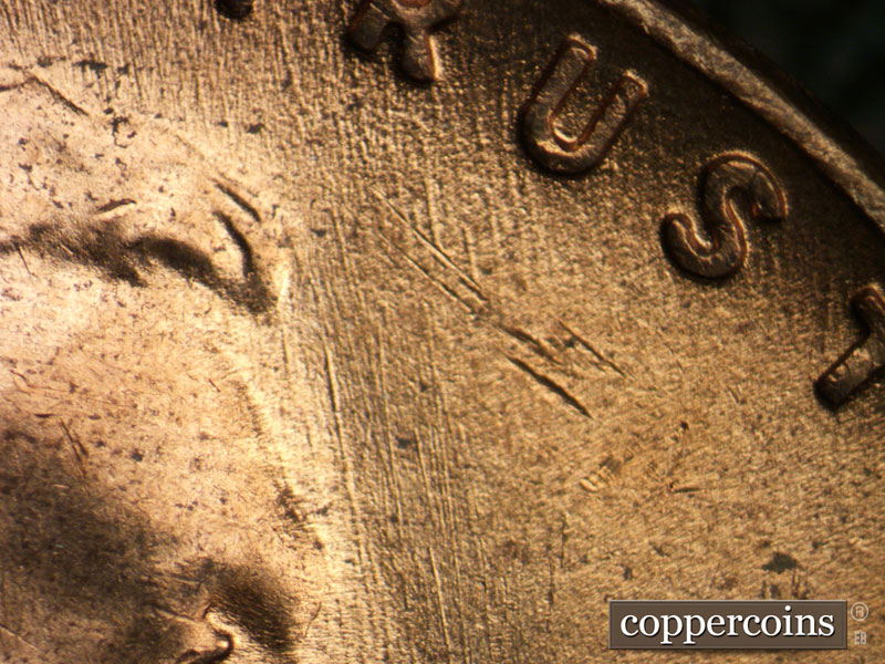 Die-stage C marker on 1953D•1MM•053 showing NNW die scratches in field in fron of forehead.