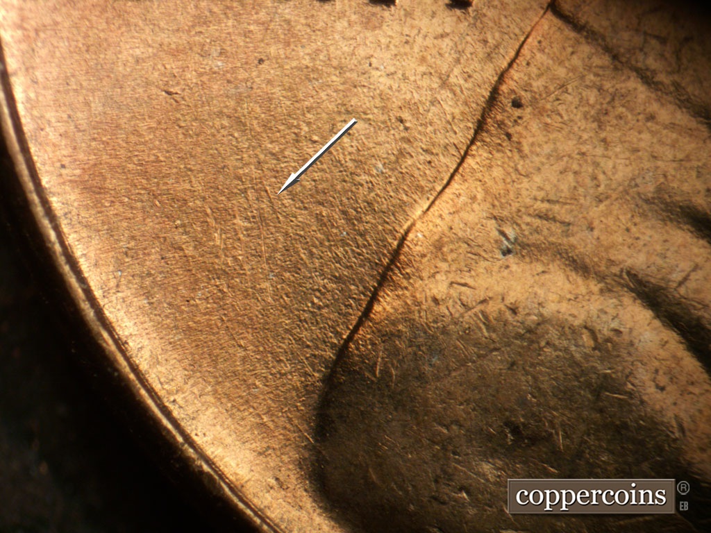 Die-stage B marker on 1953P•1DO•004 showing Concentric die scratch from back of jacket.