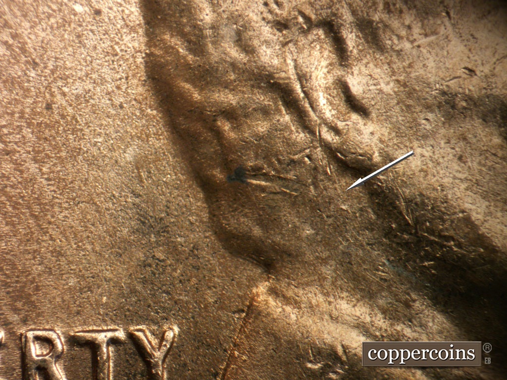 Die-stage B marker on 1954D•1MM•046 showing Weak die scratch under ear.