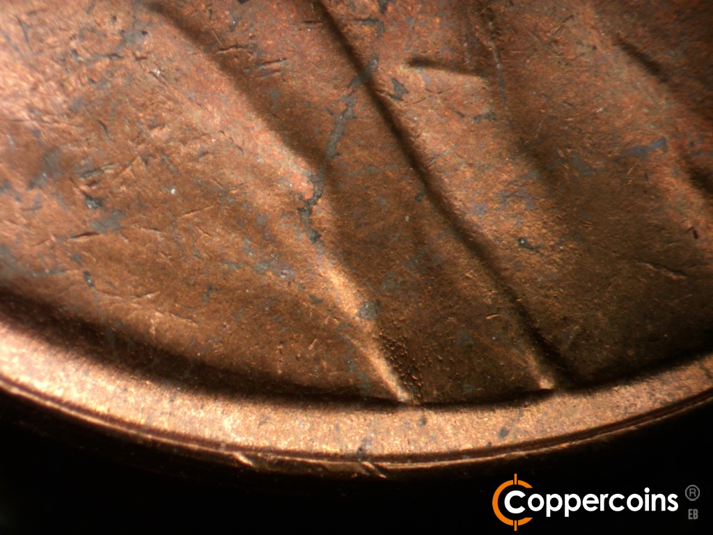 Die-stage B marker on 1954P•1DO•004 showing Die rust marks in shoulder fold.