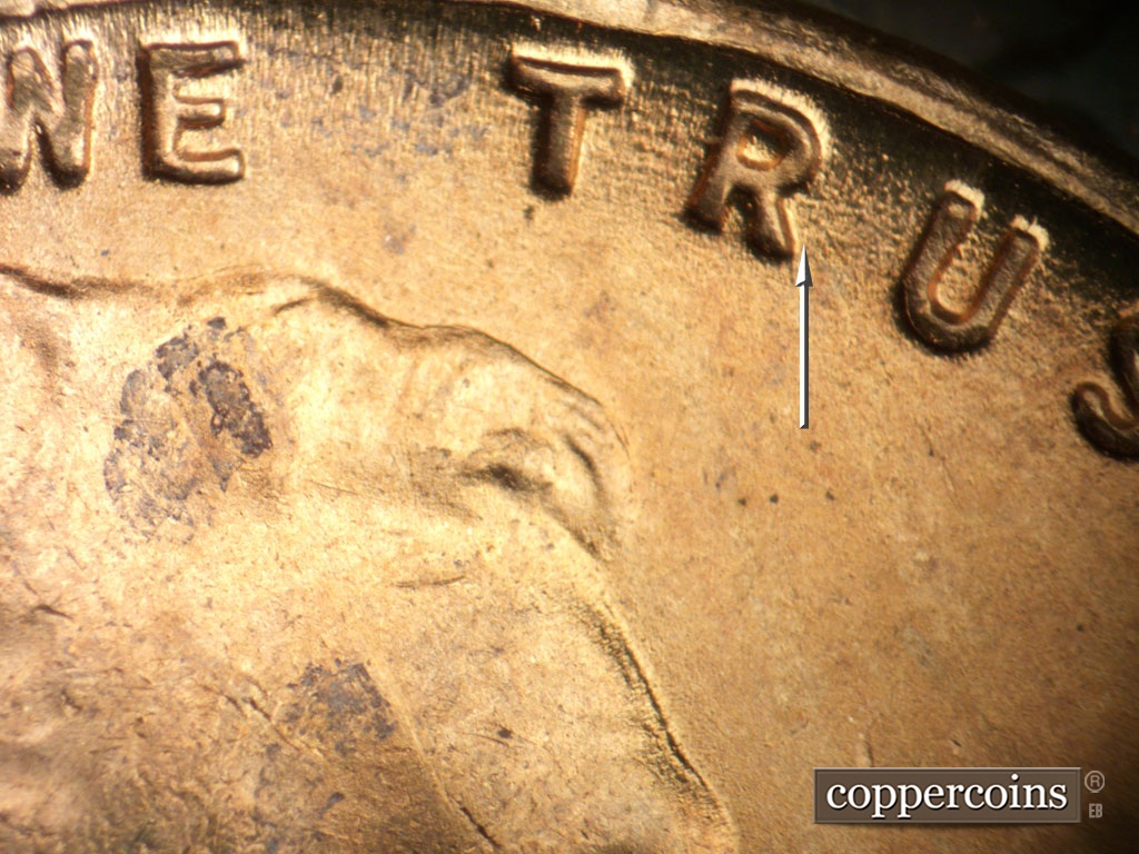 Die-stage B marker on 1954S•1DO•002 showing Worn die scratches through TR in TRUST.