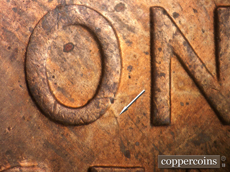 Die-stage B marker on 1954S•1MM•007 showing A die gouge points SE from the lower right area of the O of ONE.