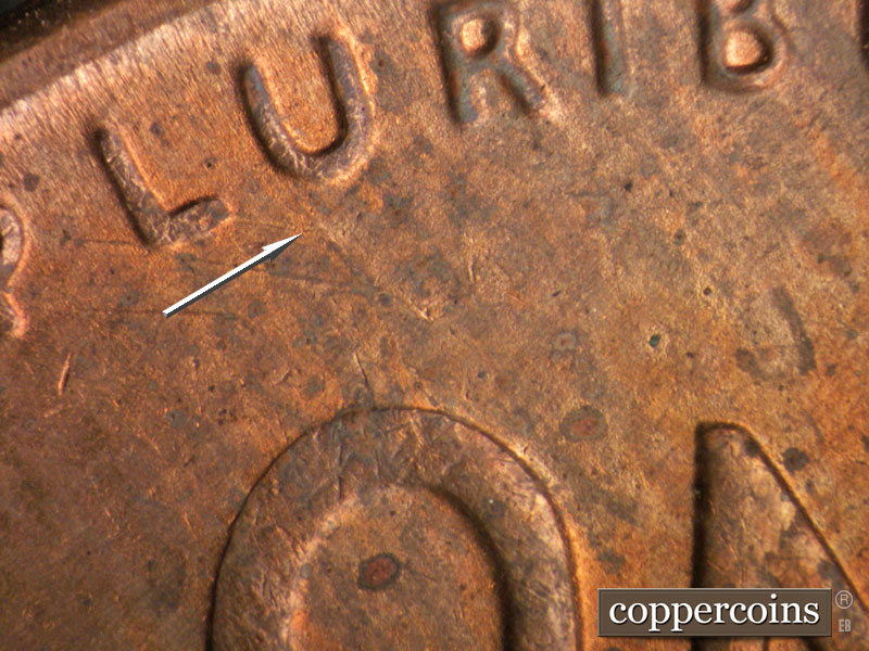 Die-stage B marker on 1954S•1MM•007 showing SE die scratch from U in PLURIBUS.