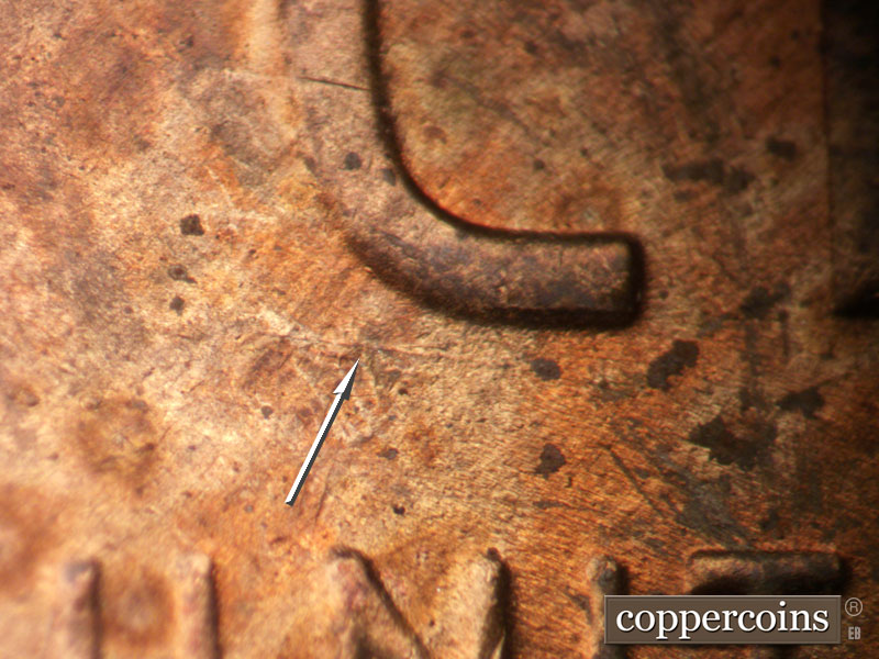 Die-stage B marker on 1954S•1MM•007 showing E-W Die scratches show above the UN of UNITED.
