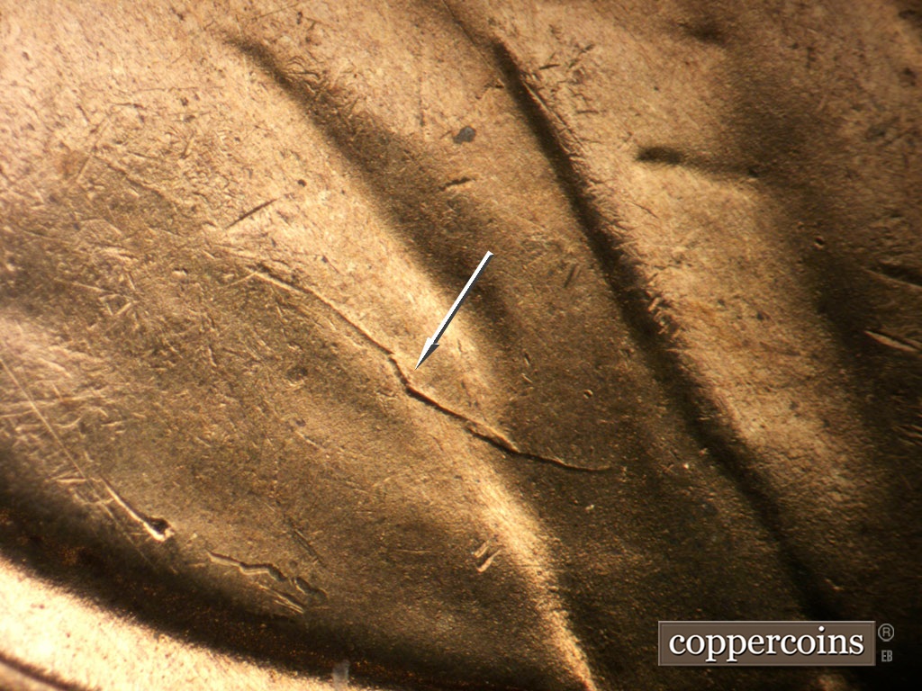 Die-stage D marker on 1954S•1MM•007 showing Die crack on shoulder.