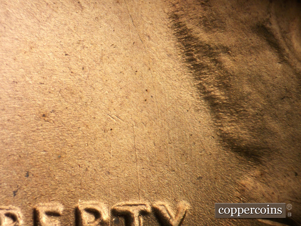 Die-stage D marker on 1954S•1MM•007 showing Worn die scratches from top of RTY in LIBERTY.