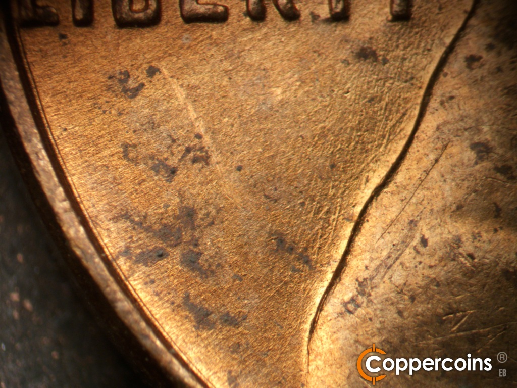 Die-stage B marker on 1955D•1DO•016 showing Concentric die scratch near rim.