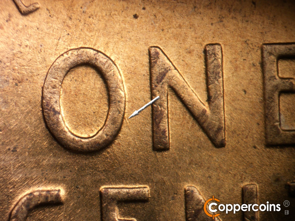 Die-stage B marker on 1955D•1DO•016 showing Short SE die scratch from O in ONE.