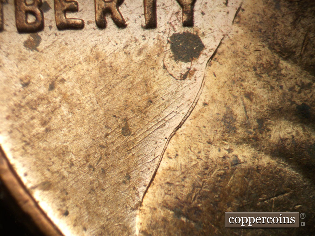 Die-stage B marker on 1955D•1MM•003 showing NE die scratches in field under LIBERTY.