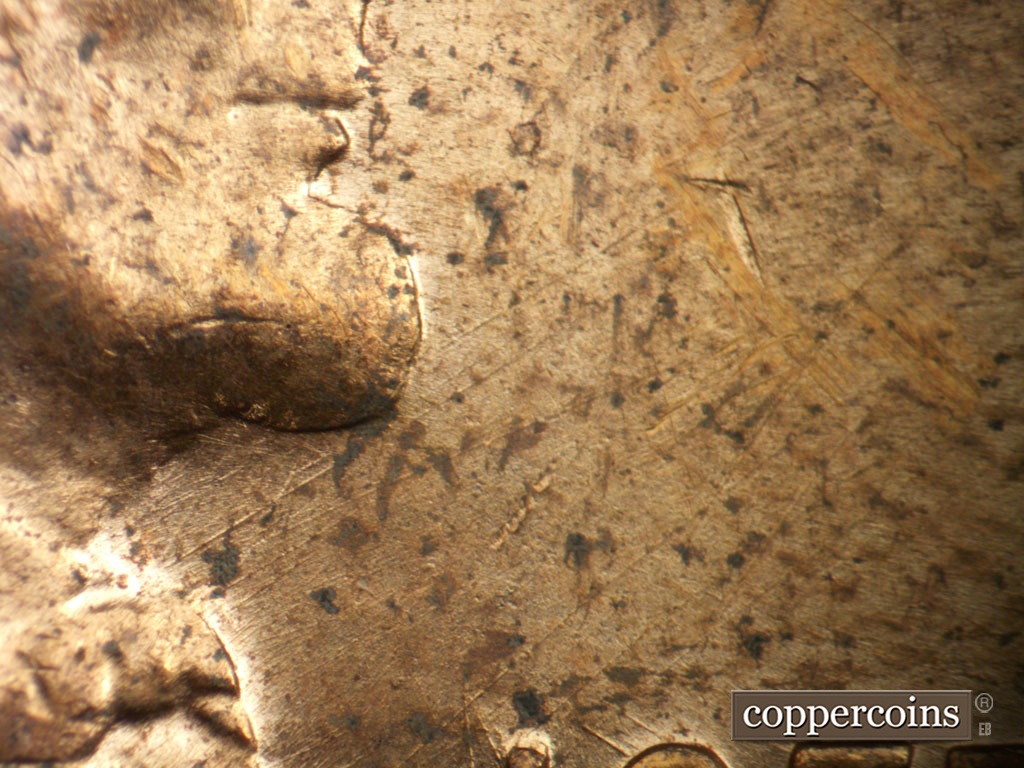 Die-stage B marker on 1955D•1MM•003 showing NE die scratches from throat.