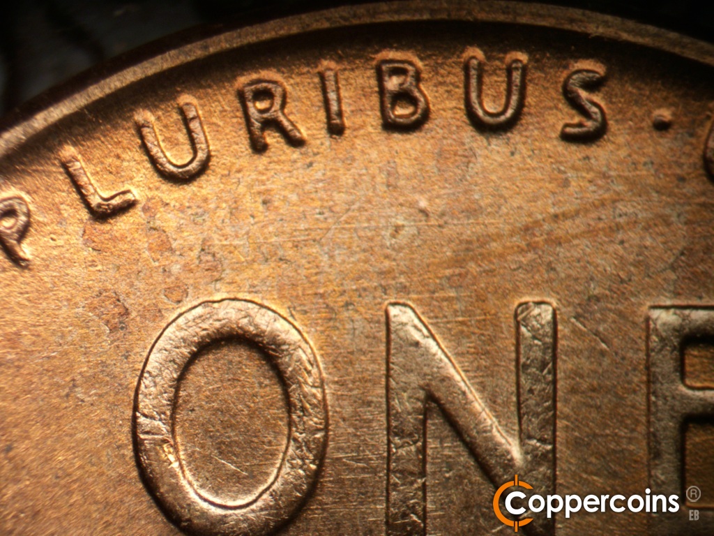 Die-stage C marker on 1955D•1MM•072 showing E/W die scratches in field under PLURIBUS.