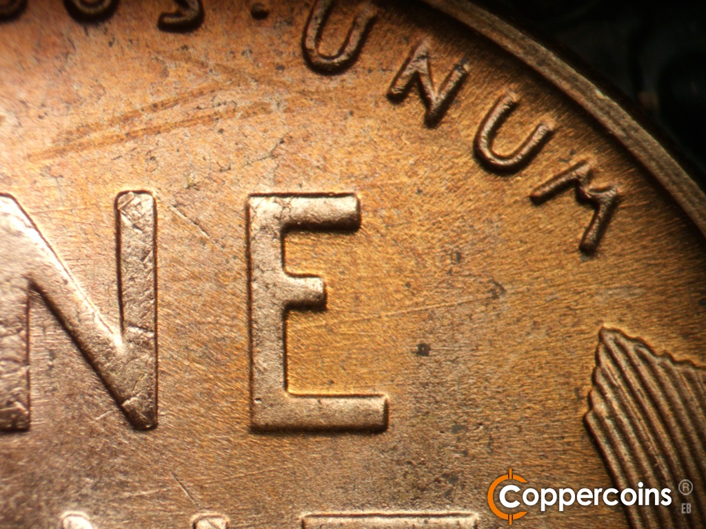 Die-stage C marker on 1955D•1MM•072 showing Stron ENE die scratch from inside E of ONE.