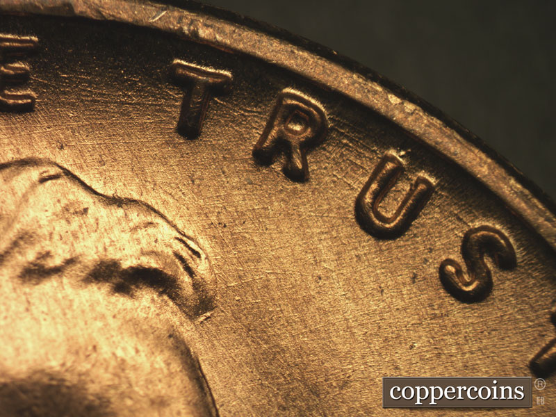 Die-stage B marker on 1955S•1MM•002 showing Concentric die scratches through TRUST.
