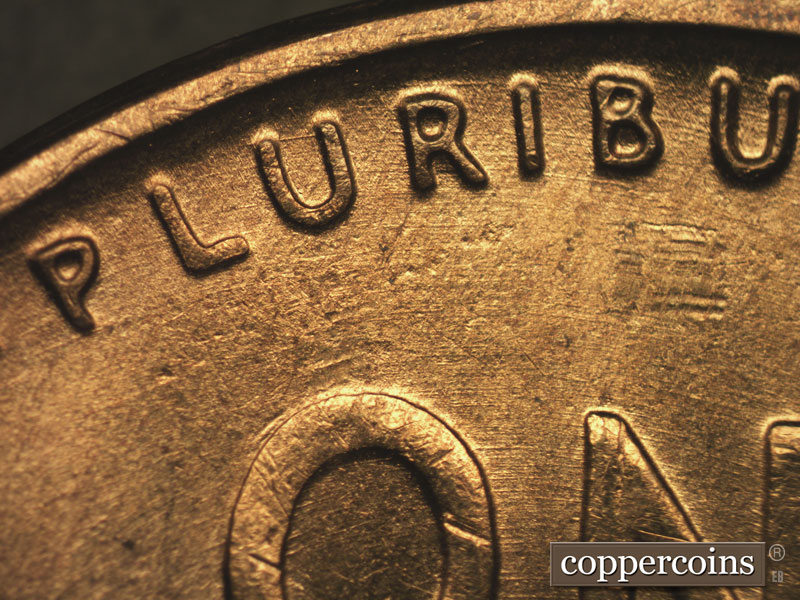 Die-stage B marker on 1955S•1MM•002 showing Concentric die scratches through PLURIBUS.