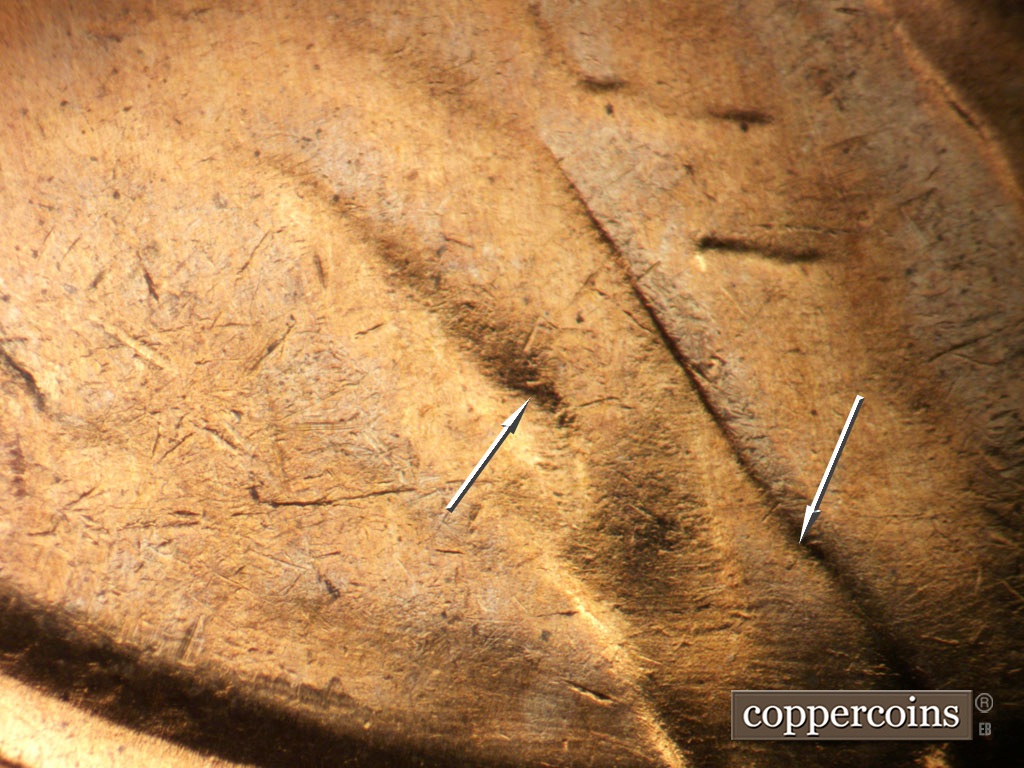 Die-stage B marker on 1955S•1MM•019 showing Die dot on jacket and in shoulder fold.