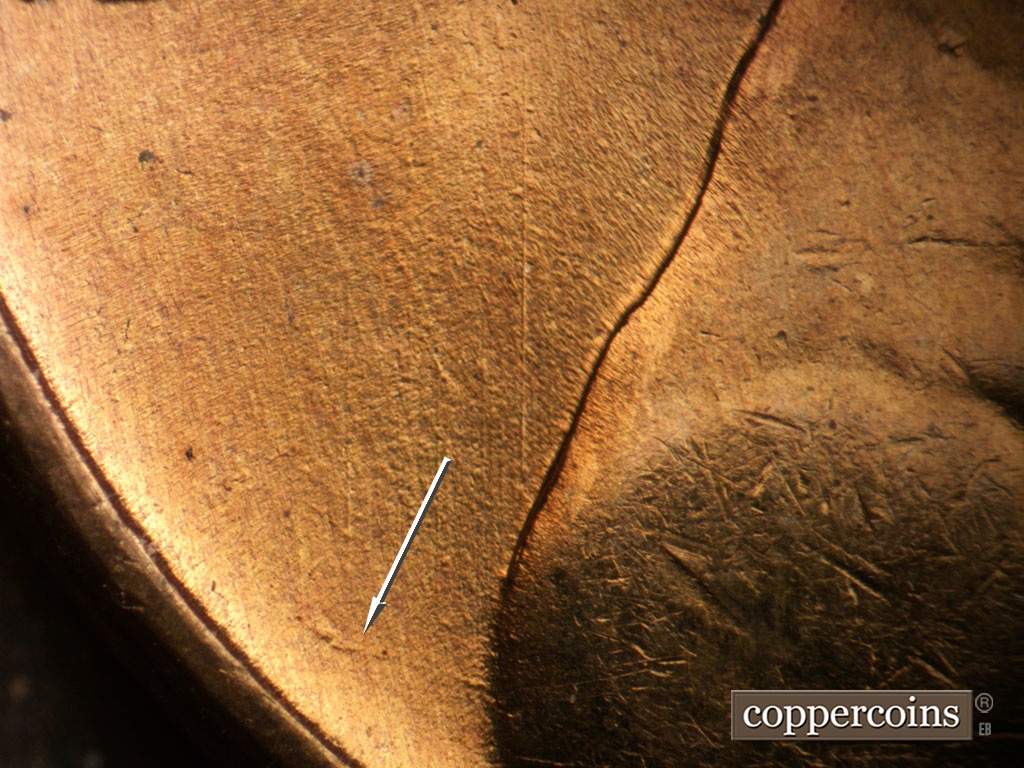 Die-stage B marker on 1955S•1MM•019 showing Unique die scratch bfrom back of shoulder.