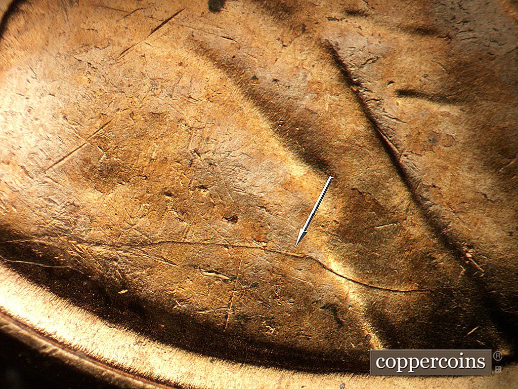 Die-stage B marker on 1956D•1DO•047 showing Die crack across shoulder.
