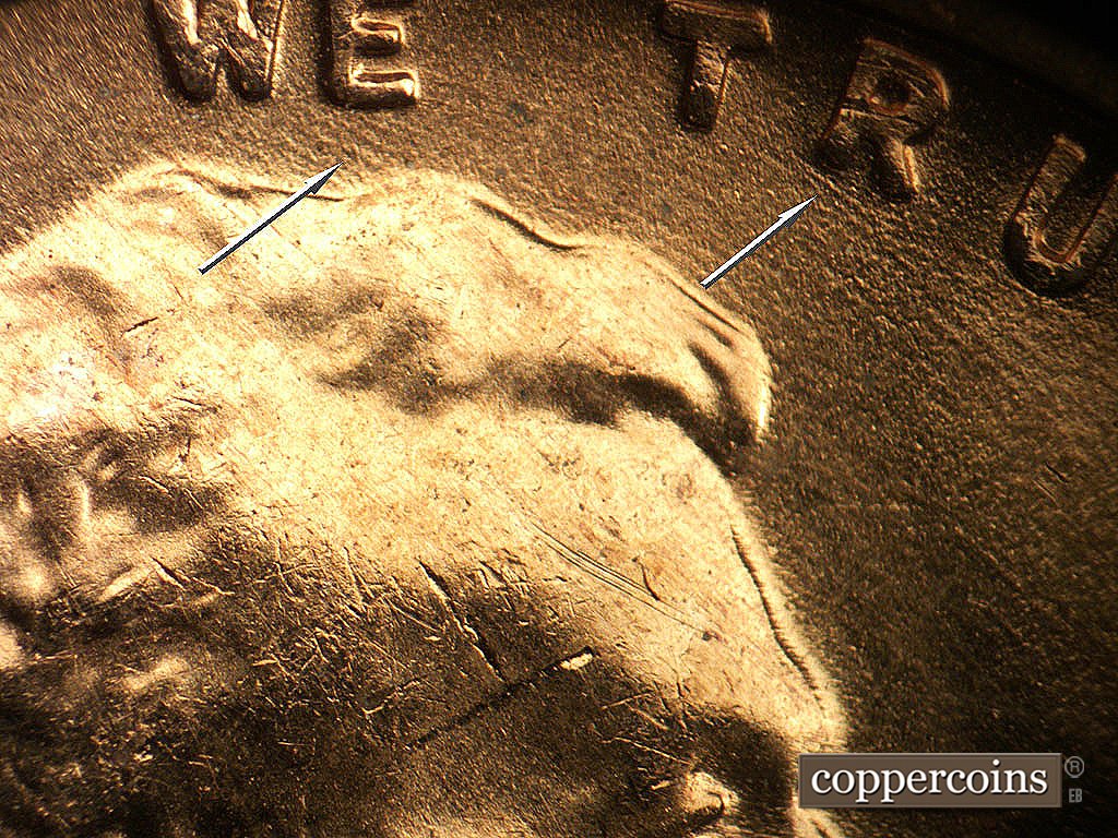 Die-stage B marker on 1956D•1DO•048 showing SE die scratches under WE and TRUST.
