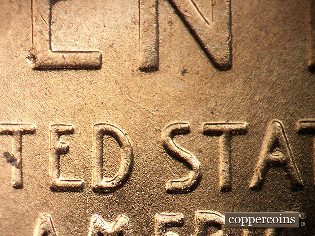 Die-stage B marker on 1956D•1MM•011 showing SE die scratches through first S in STATES.