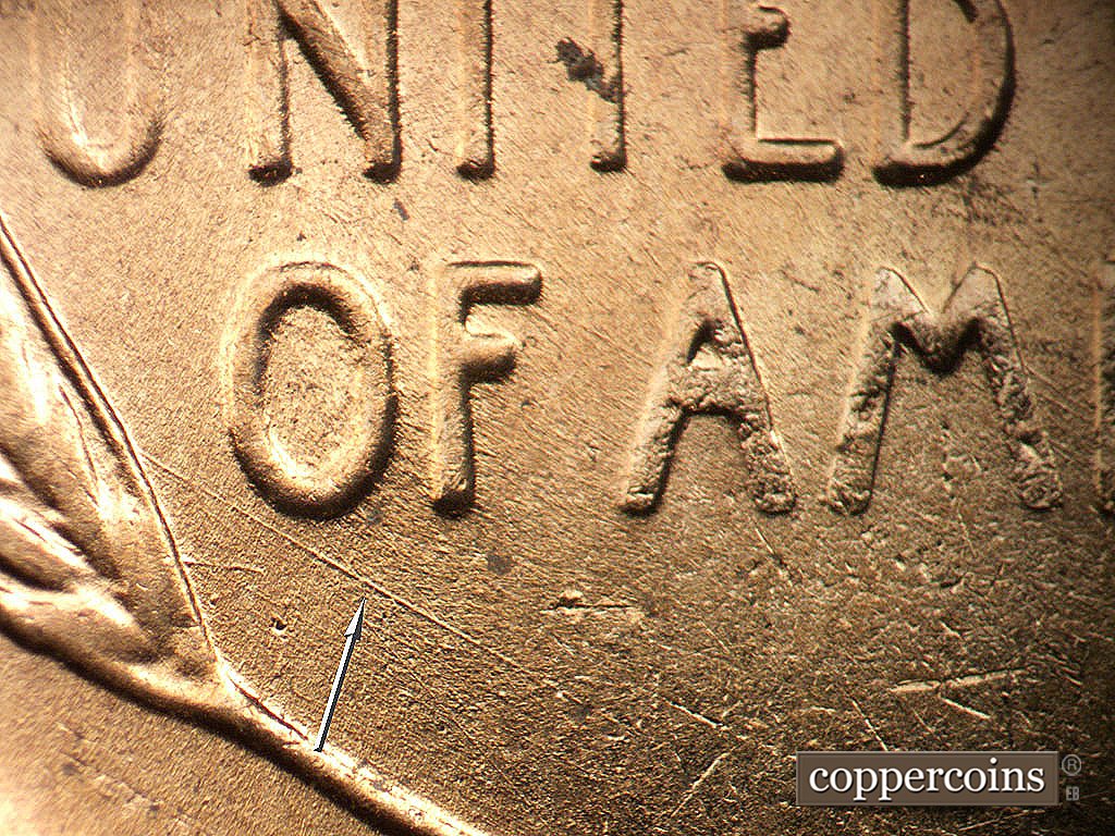 Die-stage B marker on 1956D•1MM•011 showing SE die scratch just under OF.