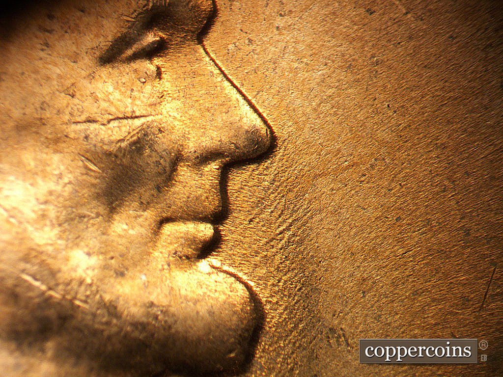 Die-stage C marker on 1956D•1MM•023 showing Worn NE die scratches in front of mouth.