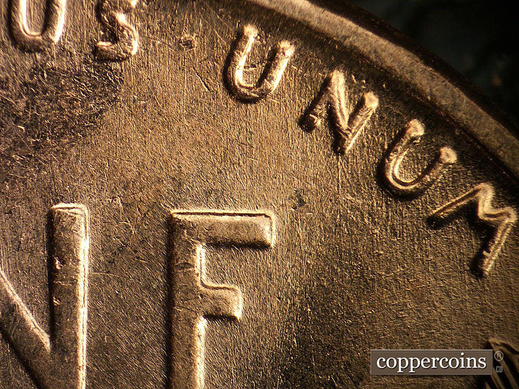 Die-stage B marker on 1956D•1MM•030 showing N/S die scratches through UNUM.
