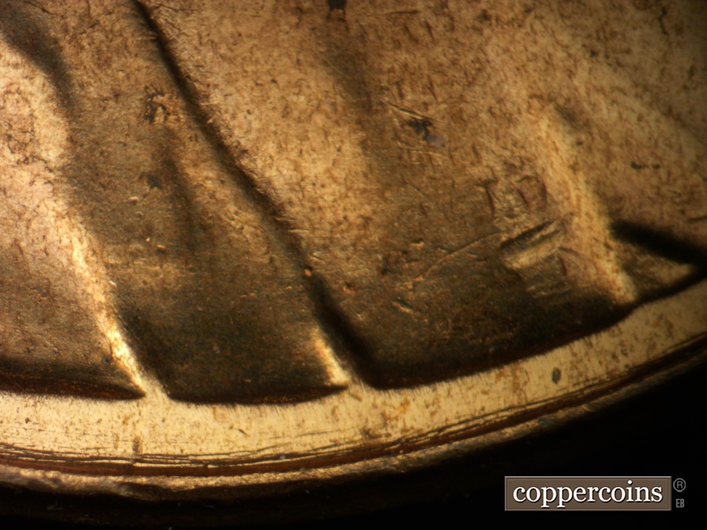 Die-stage A marker on 1957D•1DO•040 showing Concentric die scratches between rim and bottom of bust.