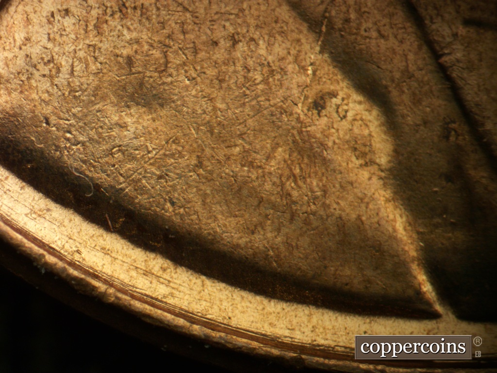 Die-stage A marker on 1957D•1DO•040 showing Concentric die scratches between rim and bottom of bust.