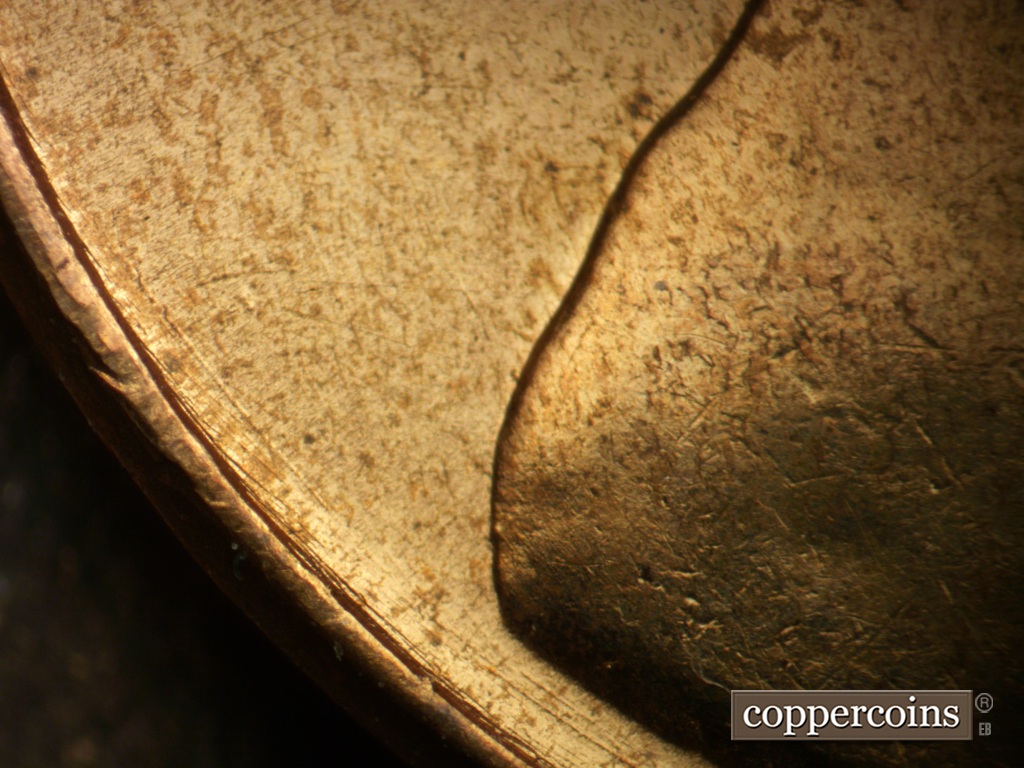 Die-stage A marker on 1957D•1DO•040 showing Concentric die scratches between rim and back of shoulder.