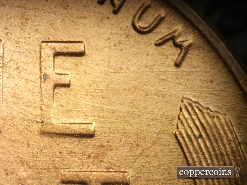Die-stage A marker on 1957D•1DO•040 showing E/W die scratches from E in ONE to rim.