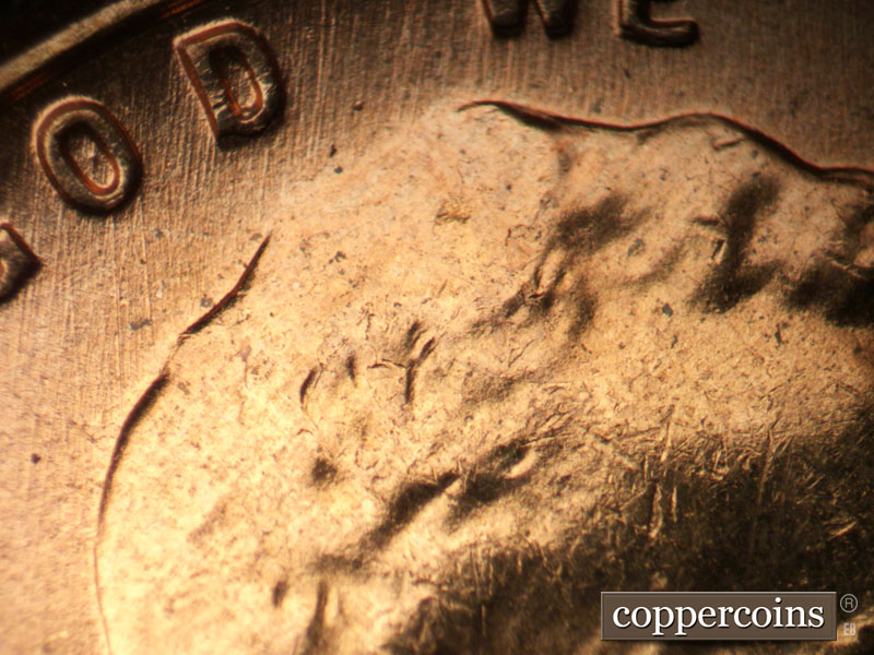 Die-stage B marker on 1957D•1MM•093 showing N/S die scratch through IN GOD WE.