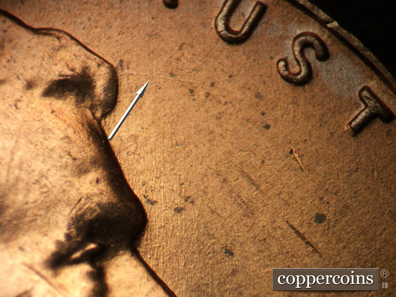 Die-stage B marker on 1957D•1MM•093 showing E/W die scratch from tip of hair. N/S die scratches in field in front of hair.