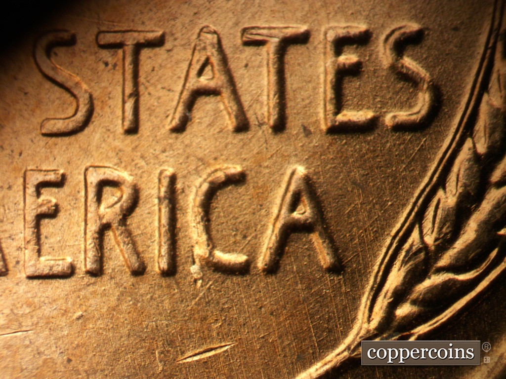 Die-stage A marker on 1957D•1MM•093 showing SW die scratch through bottom of C in AMERICA.