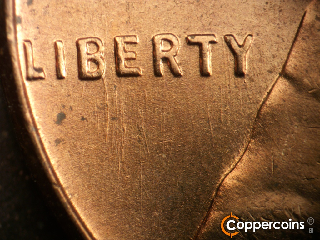 Die-stage B marker on 1957D•1MM•104 showing Curved die scratch from base of B in LIBERTY.