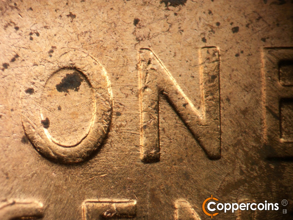 Die-stage B marker on 1957D•1MM•104 showing E/W die scratches connect ON in ONE.