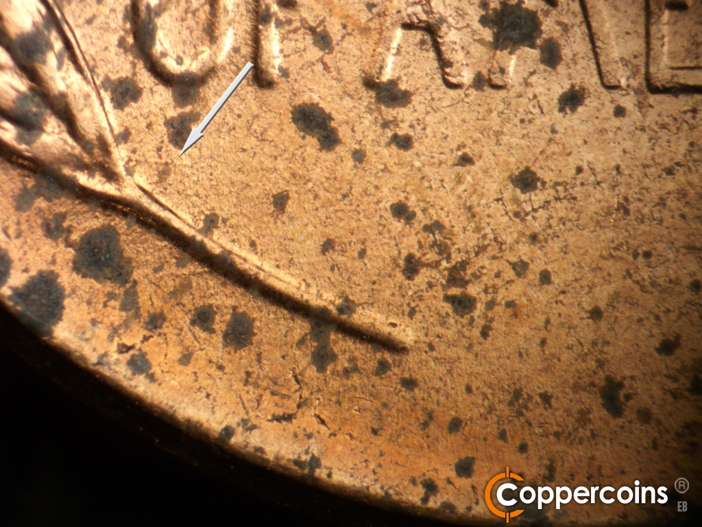 Die-stage B marker on 1957D•1MM•104 showing Short E/W die scratch from bottom of left wheat stalk.