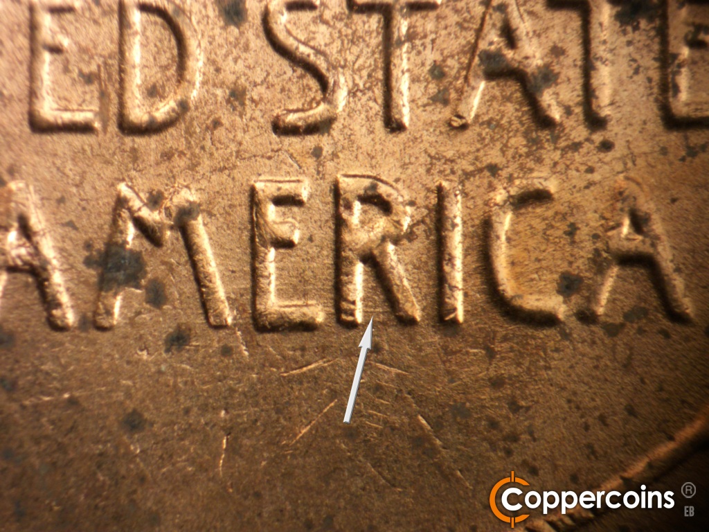 Die-stage B marker on 1957D•1MM•104 showing DIe scratch connect legs in R of AMERICA.