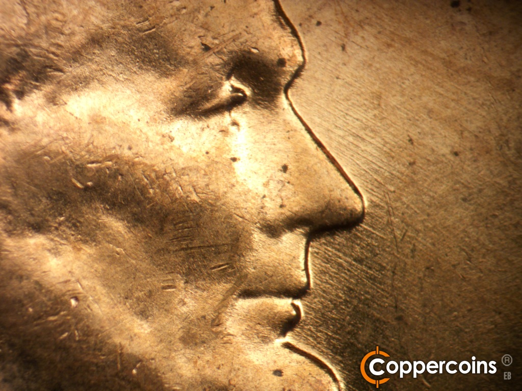 Die-stage B marker on 1957D•1MM•109 showing Light SE die scratches in front of face.