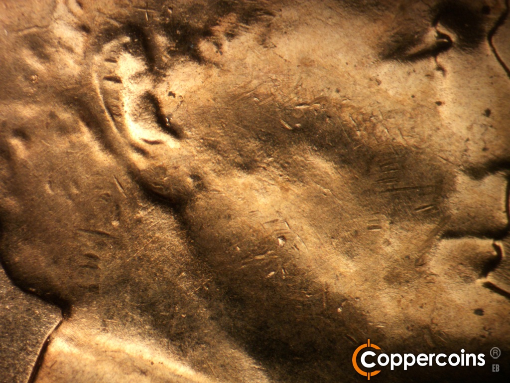 Die-stage B marker on 1957D•1MM•109 showing Light concentric die scratches under ear.