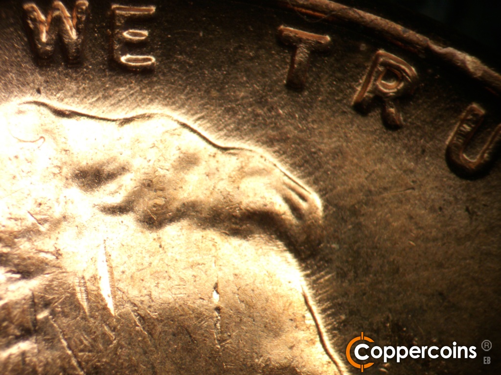 Die-stage C marker on 1957D•1MM•110 showing Short NE die scratches from top of hair.