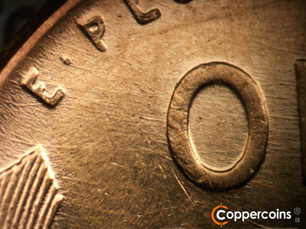 Die-stage C marker on 1957D•1MM•110 showing Die scratches cover upper left of reverse.