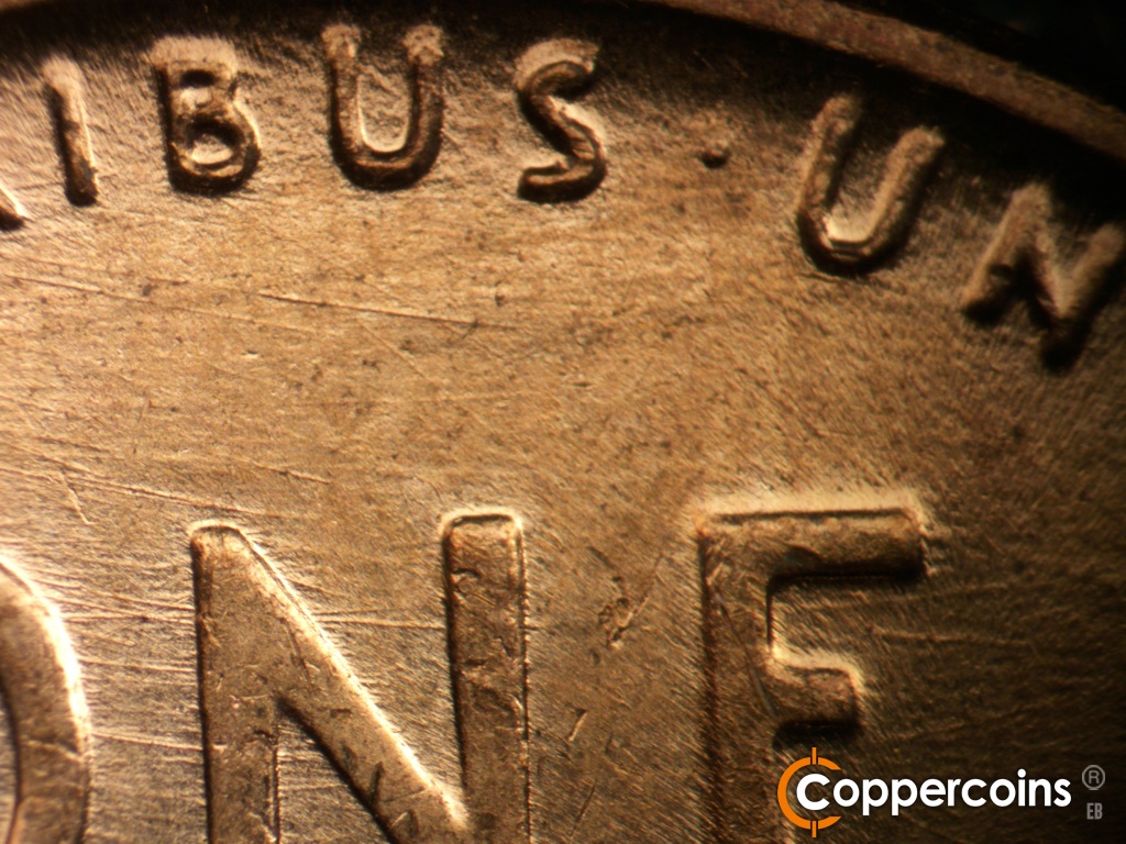 Die-stage C marker on 1957D•1MM•110 showing Die scratches cover upper center of reverse.