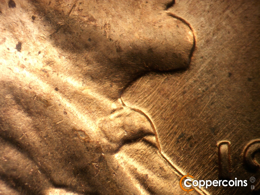 Die-stage B marker on 1957D•1MM•111 showing NE die scratches in front of throat.