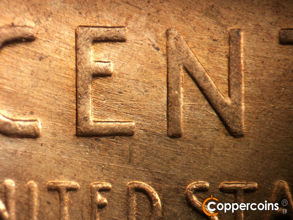 Die-stage B marker on 1957D•1MM•111 showing ESE die scratches through CE in CENT.