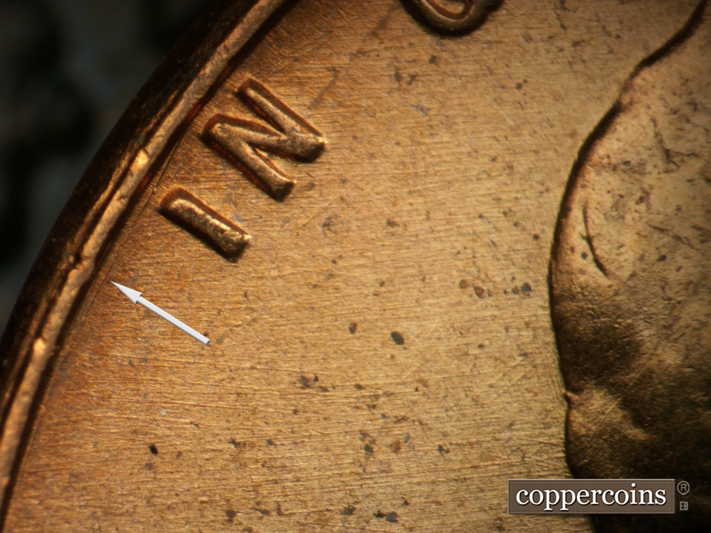 Die-stage B marker on 1957P•1DO•007 showing Concentric die scratch between rim and IN.E/W die scratch in field behind head.