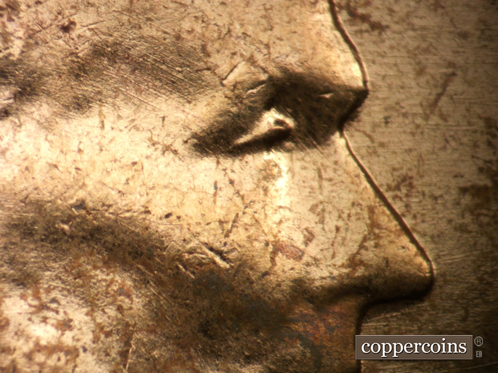 Die-stage A marker on 1957P•1DO•007 showing Extra lower eyelid north of primary. Die scratches on temple.