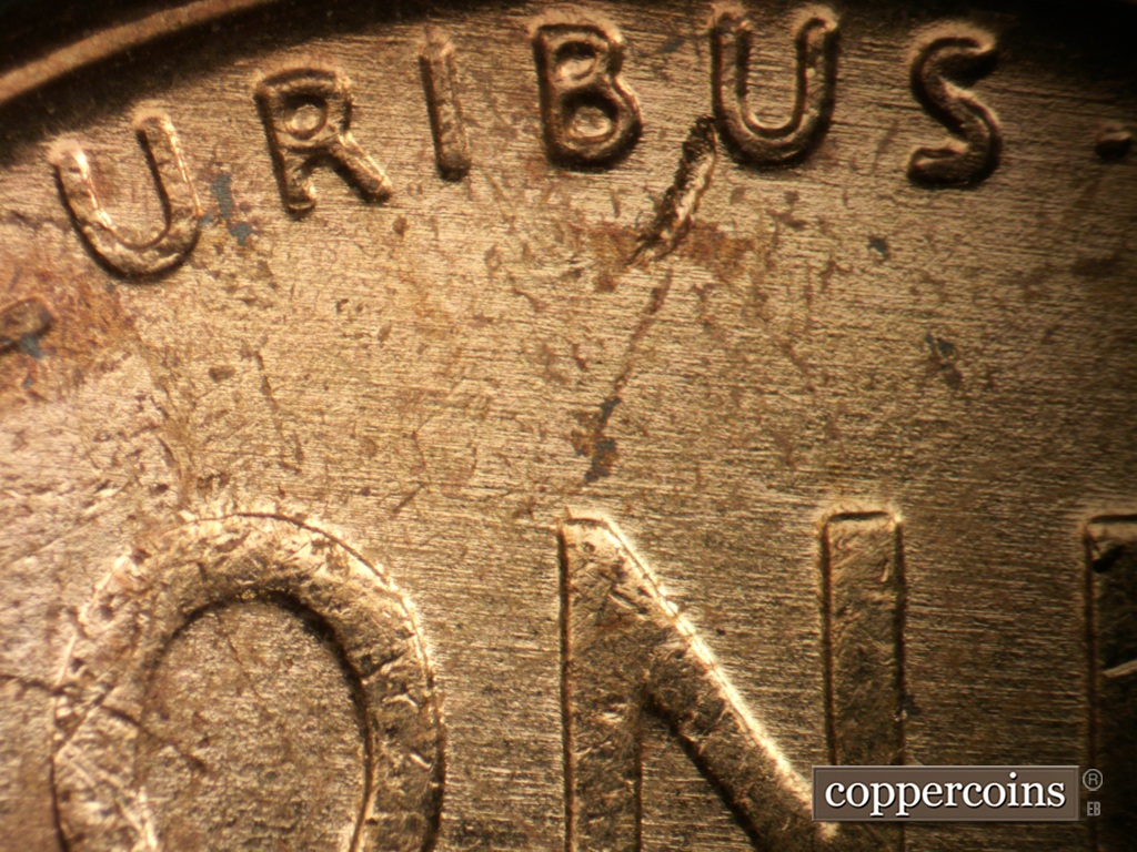 Die-stage A marker on 1957P•1DO•007 showing Generally E/W die scratches cover top of reverse.
