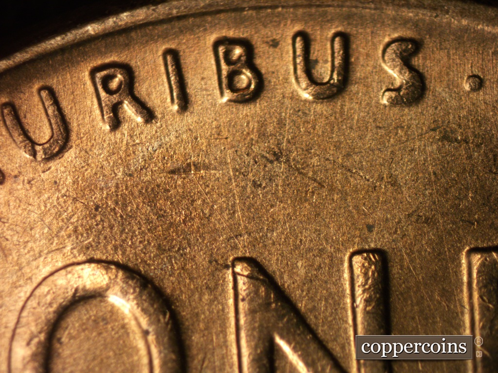 Die-stage B marker on 1958D•1MM•049 showing Light and thin die scrtatches show through the upper field.